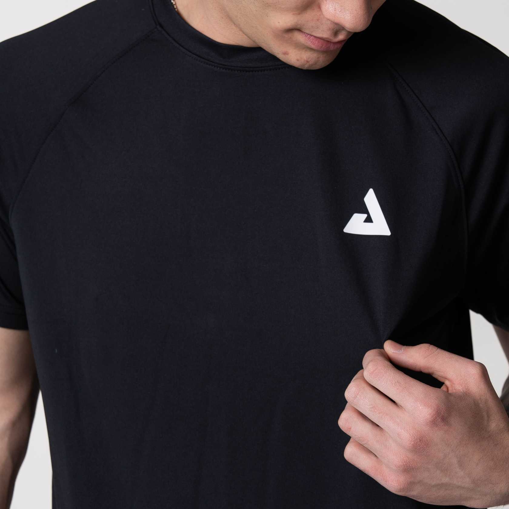 Close up on the white JOOLA trinity logo on the a black JOOLA Court Short Sleeve shirt.